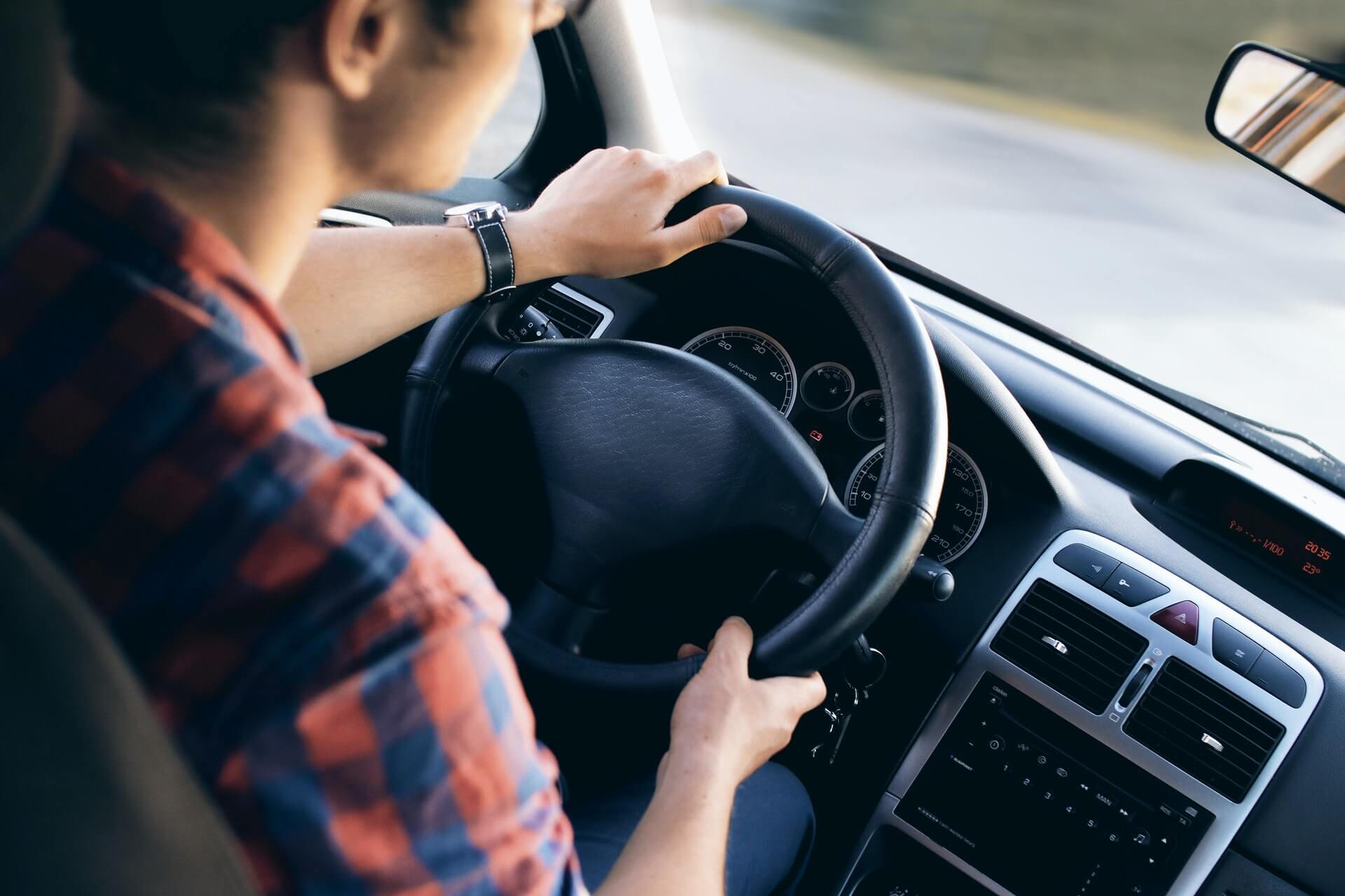 man steering car